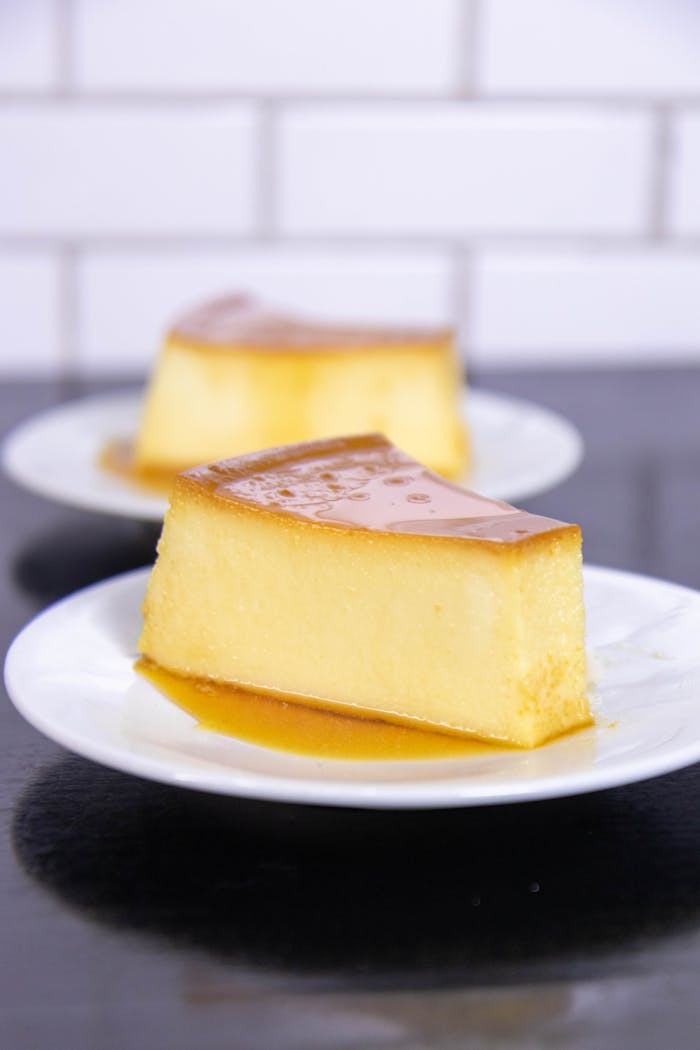 Services Appetizing slice of caramel-topped flan on a white plate, perfect for dessert lovers.